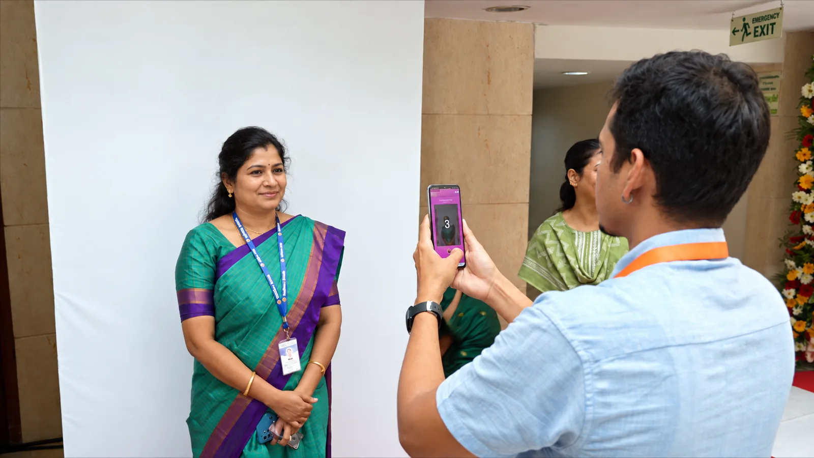Guest posing at the Playtown AI Photobooth while a staff member takes her photo